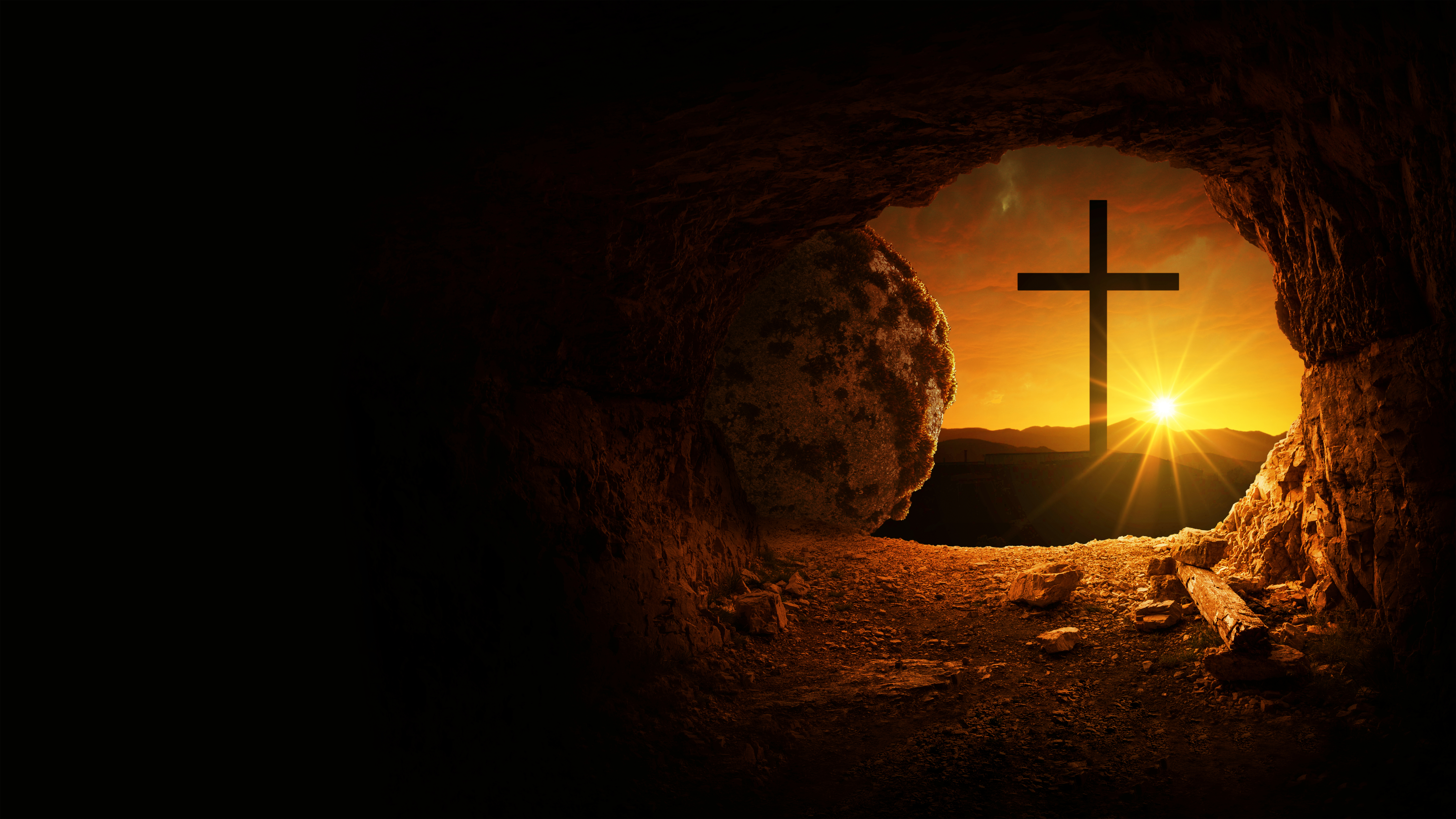 Easter and Good Friday concept, empty tomb with cross on mountain with amazing sunrise. Creative idea Easter. Religion and Christianity. Open empty cave with sunset view. Free copy space for design